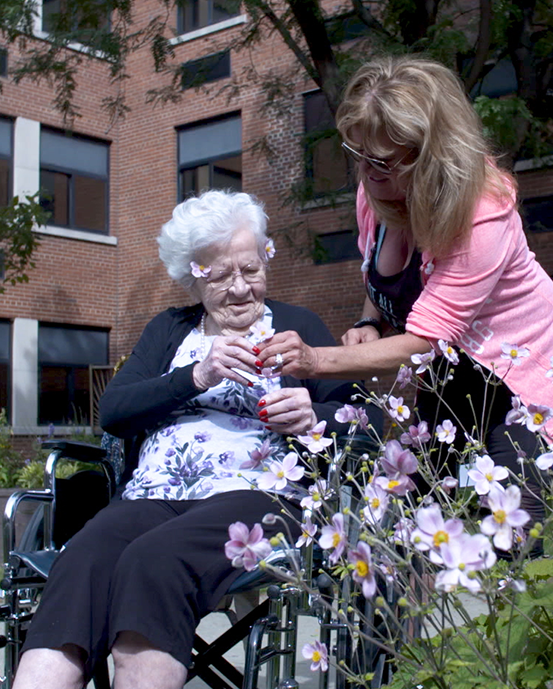 Employee walks with a Female Elderly Patient